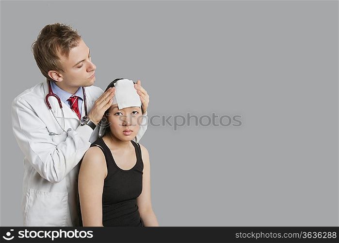 Doctor adjusting bandage on patient&acute;s head
