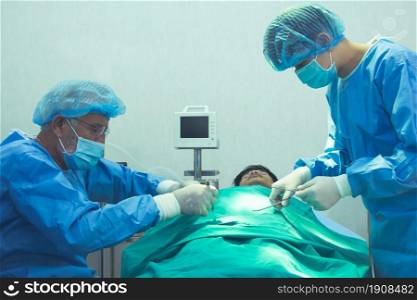 Doctor and his assistance of medical team urgently doing surgical operation and helping patient in theater at hospital