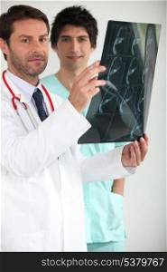 Doctor and male nurse examining x-ray image