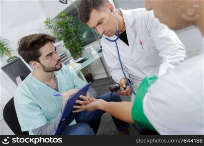 doctor and nurse measuring blood pressure