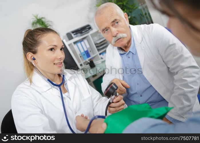 doctor and nurse measuring blood pressure of a patient