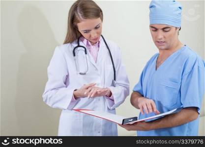 Doctor and nurse reading information from file folder