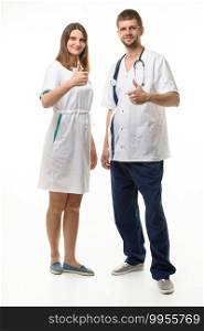 Doctor and nurse show hand gesture thumbs up and look happily into frame