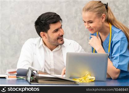 Doctor and nurse working with laptop computer in hospital office. Healthcare and medical concept.