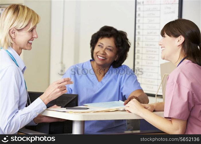 Doctor And Nurses In Discussion At Nurses Station