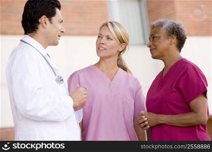 Doctor And Nurses Standing Outside A Hospital