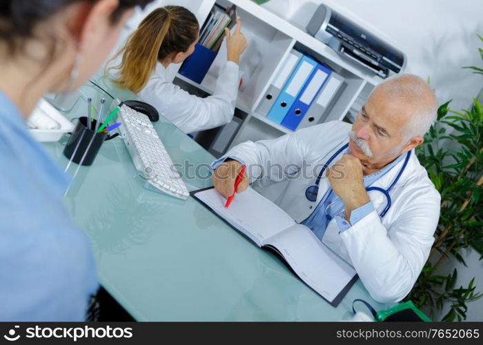 doctor and patient in hospital office during regular medical exam