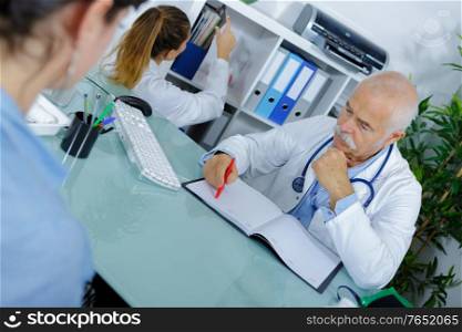 doctor and patient in hospital office during regular medical exam