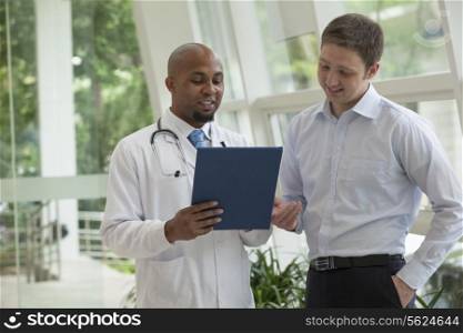 Doctor and patient looking down and discussing medical record in the hospital
