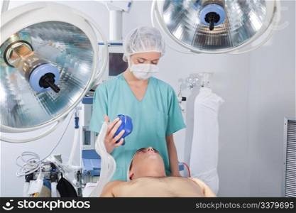 Doctor applying oxygen mask on patient before operation