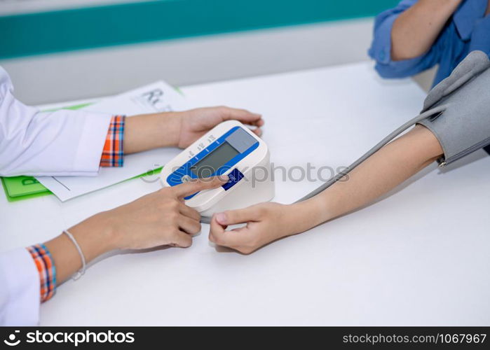 doctor asian women checking woman patient with pressure in clinic Thailand health care concept