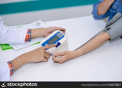 doctor asian women checking woman patient with pressure in clinic Thailand health care concept