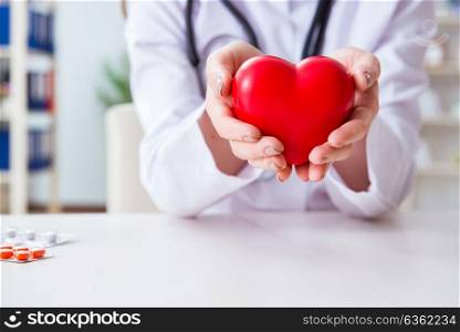 Doctor cardiologist with red heart in the hospital