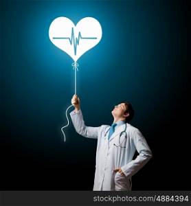 Doctor cardiologist. Young male doctor cardiologist with heart symbol