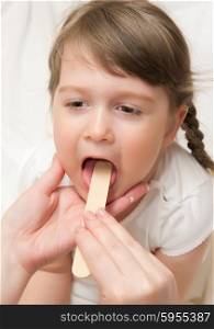 Doctor check throat of little girl
