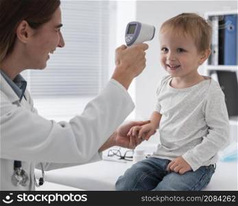 doctor checking baby s temperature