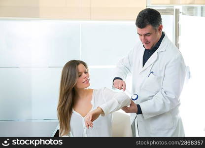 Doctor checking elbow with reflex round hammer to woman patient in hospital