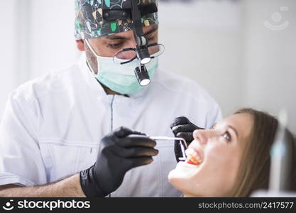 doctor checking female patient s teeth clinic