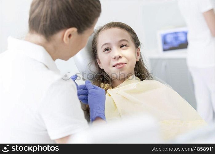 Doctor checking girl patient at dental clinic