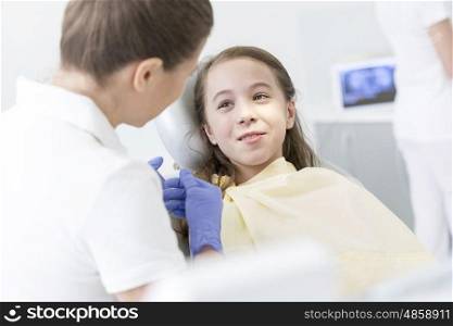 Doctor checking girl patient at dental clinic