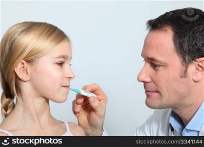 Doctor checking little girl&acute;s temperature