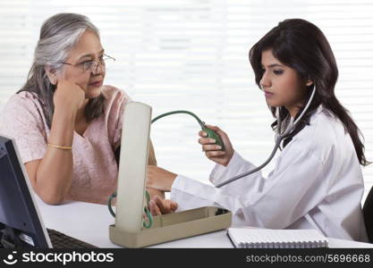 Doctor checking patient&rsquo;s blood pressure
