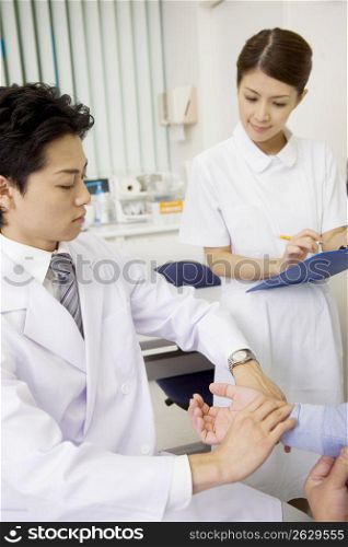 Doctor checking patient's pulse