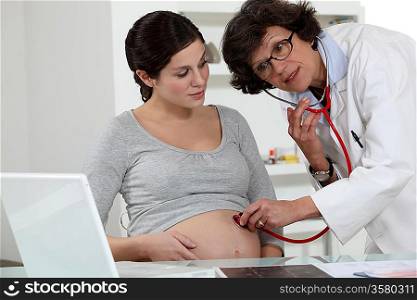 Doctor checking pregnant woman&acute;s belly