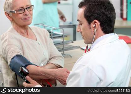 Doctor checking the blood pressure of an elderly lady