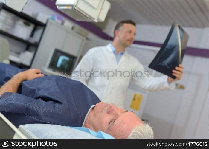 doctor checking xray of a senior patient in hospital