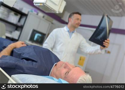 doctor checking xray of a senior patient in hospital