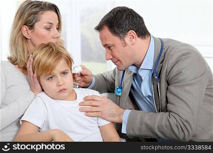 Doctor cheking little boy&acute;s ear infection