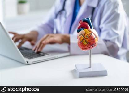 Doctor consult patient on laptop with anatomical model of human heart Cardiologist supports the heart Online doctor appointment.