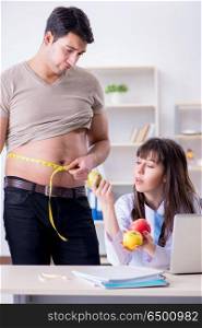 Doctor dietician giving advices to fat overweight patient