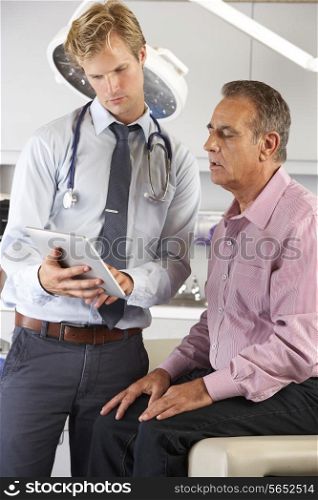 Doctor Discussing Records With Patient Using Digital Tablet