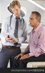 Doctor Discussing Records With Patient Using Digital Tablet