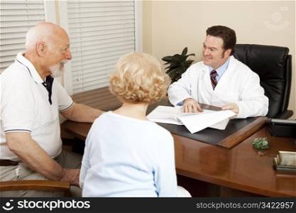 Doctor discussing treatment options with an elderly couple in his office.