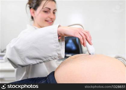 Doctor does Ultrasound or Sonogram Procedure to a Pregnant Woman in the Hospital, Close-up Shot of the Obstetrician Moving Transducer on the Belly of the Future Mother .. Doctor does Ultrasound or Sonogram Procedure to a Pregnant Woman in the Hospital, Close-up Shot of the Obstetrician Moving Transducer on the Belly of the Future Mother.