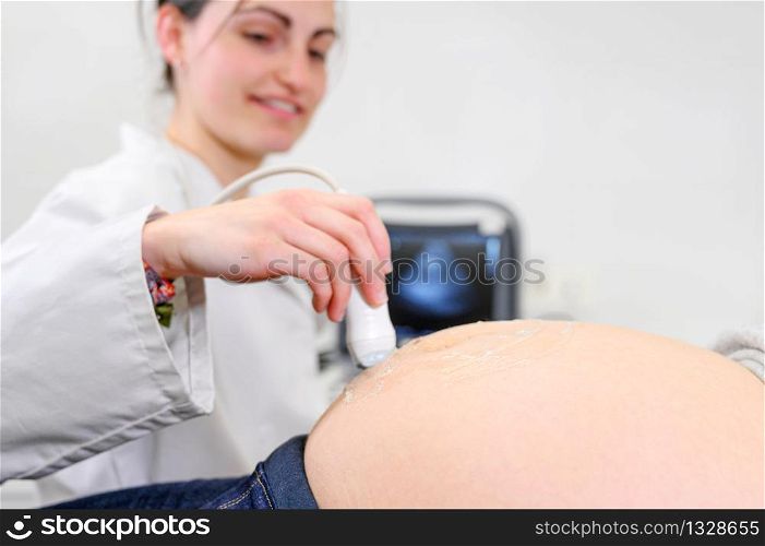 Doctor does Ultrasound or Sonogram Procedure to a Pregnant Woman in the Hospital, Close-up Shot of the Obstetrician Moving Transducer on the Belly of the Future Mother .. Doctor does Ultrasound or Sonogram Procedure to a Pregnant Woman in the Hospital, Close-up Shot of the Obstetrician Moving Transducer on the Belly of the Future Mother.