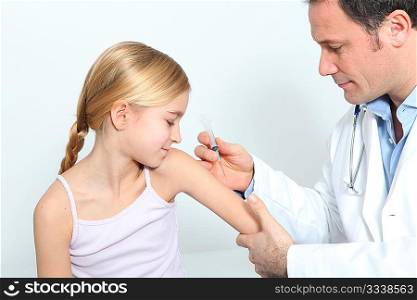 Doctor doing vaccine injection to blond little girl