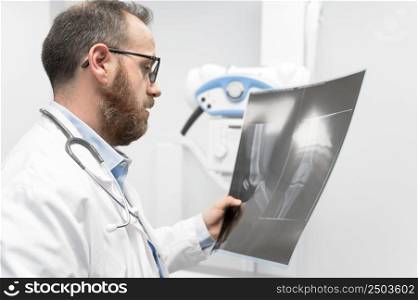 Doctor examine a film x-ray of a patient at radiology room. High quality photography.. Doctor examine a film x-ray of a patient at radiology room.
