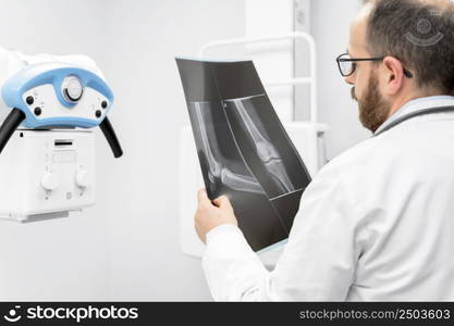 Doctor examine a film x-ray of a patient at radiology room. High quality photography.. Doctor examine a film x-ray of a patient at radiology room.