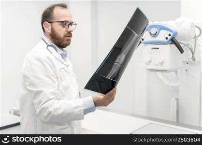Doctor examine a film x-ray of a patient at radiology room. High quality photography.. Doctor examine a film x-ray of a patient at radiology room.