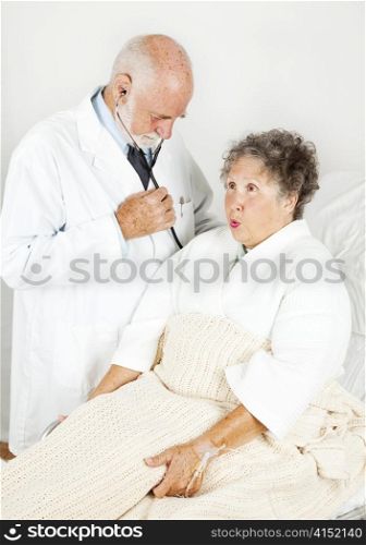 Doctor examines his elderly female patient in the hospital.