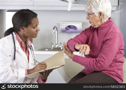 Doctor Examining Female Patient With Elbow Pain