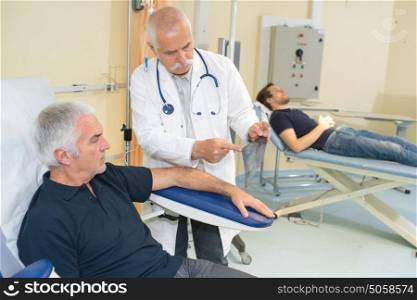 doctor examining his patient arm in medical office