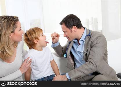 Doctor examining little boy throat