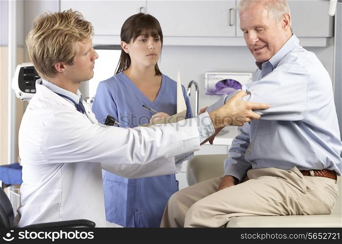 Doctor Examining Male Patient With Elbow Pain