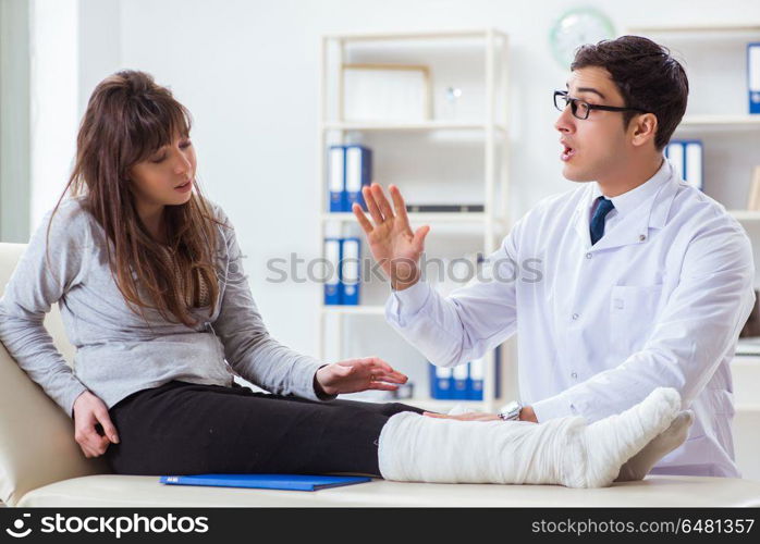 Doctor examining patient with broken leg