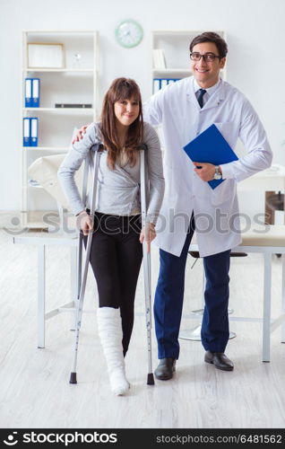 Doctor examining patient with broken leg